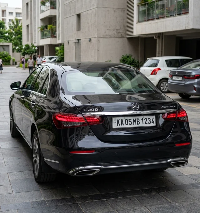 Polished rear trunk, bumper, and taillights of same black sedan after cleaning
